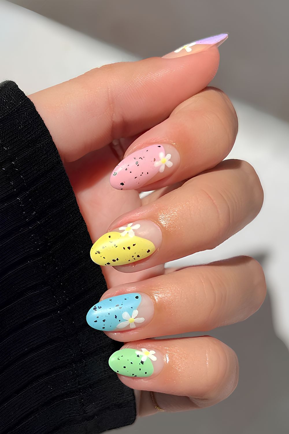Neutral nails with speckled eggs and daisy motives