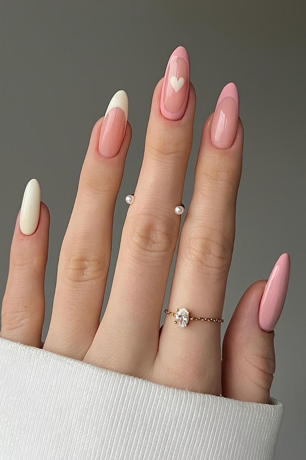 Pastel pink and creamy white French nails with heart accent