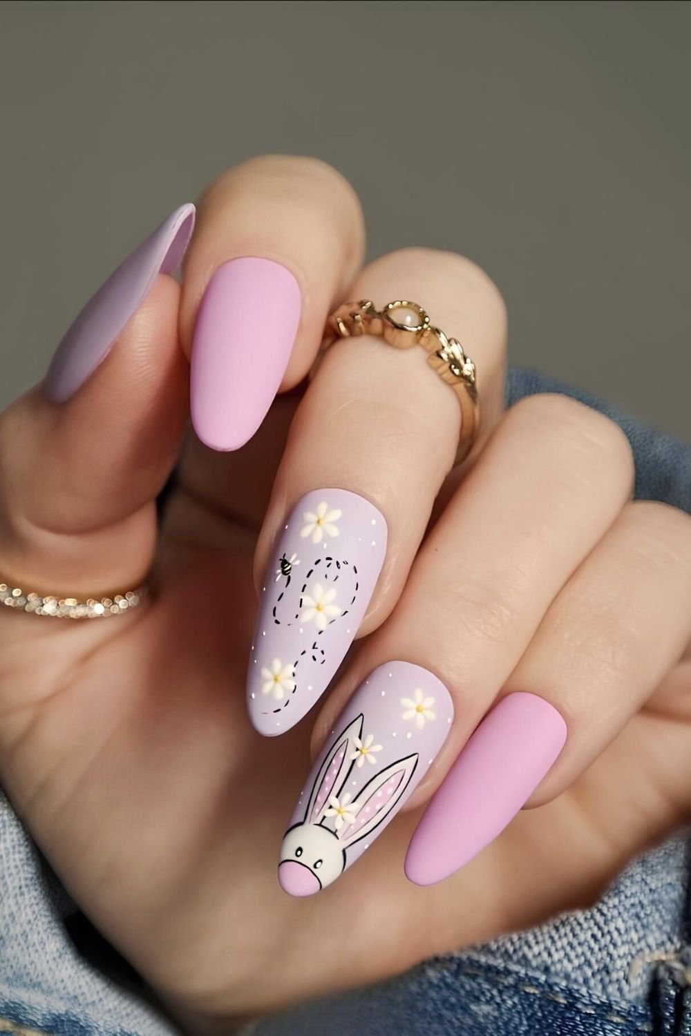 Pink and purple matte nails with bunny face accent and flowers and a bee