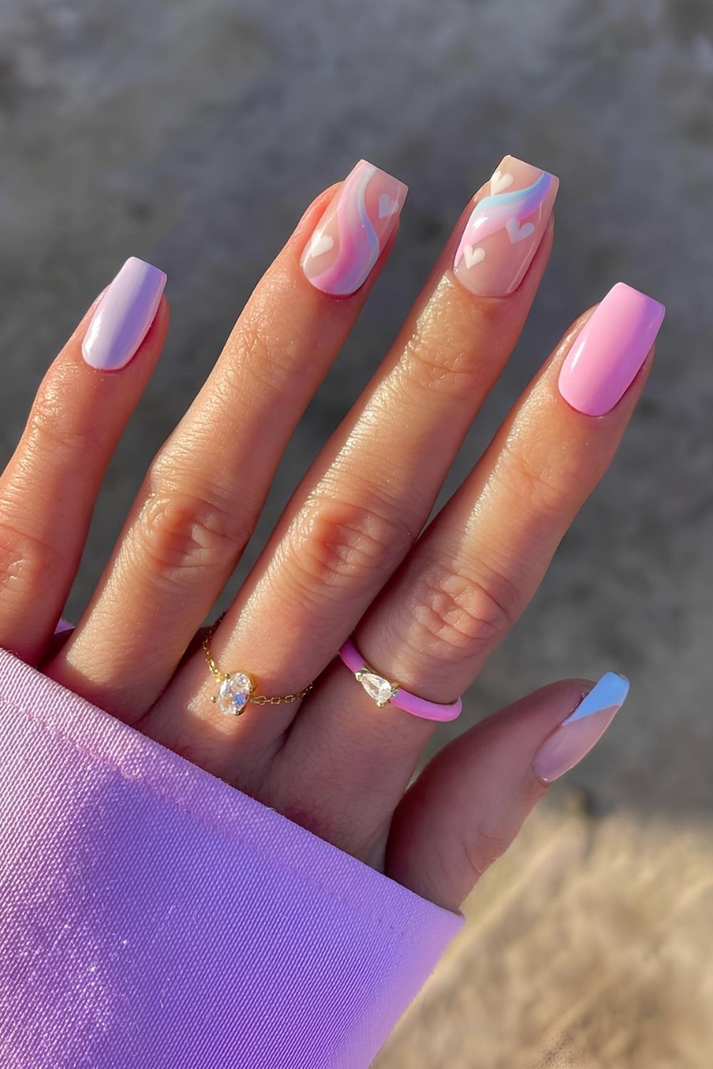 Pink and purple pastel nails with swirls and hearts