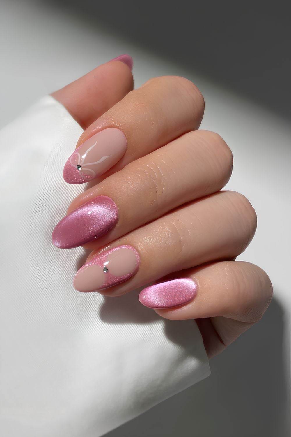 Pink cat eye nails with bows and gems