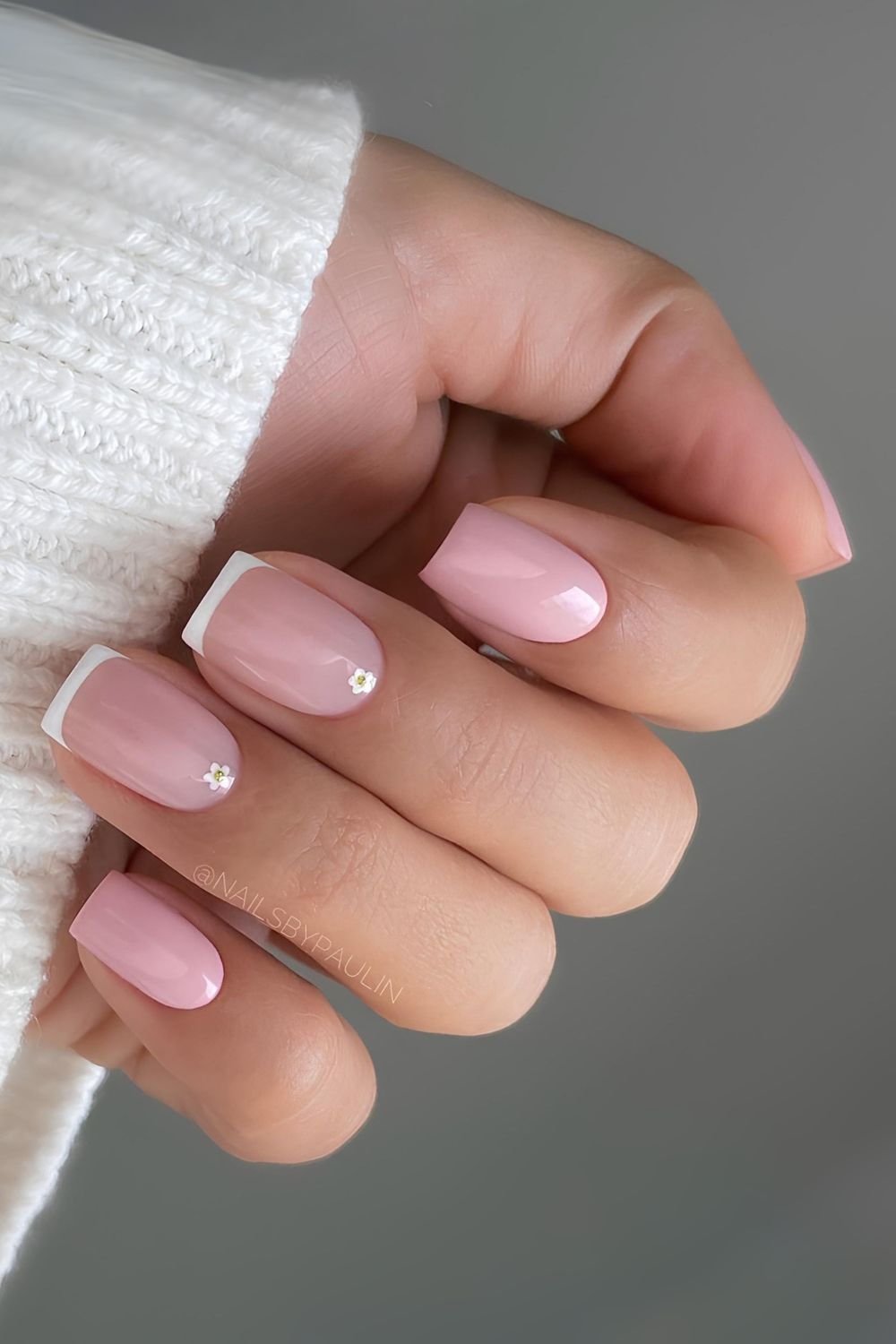 Powder pink nails with white micro french and subtle floral accents