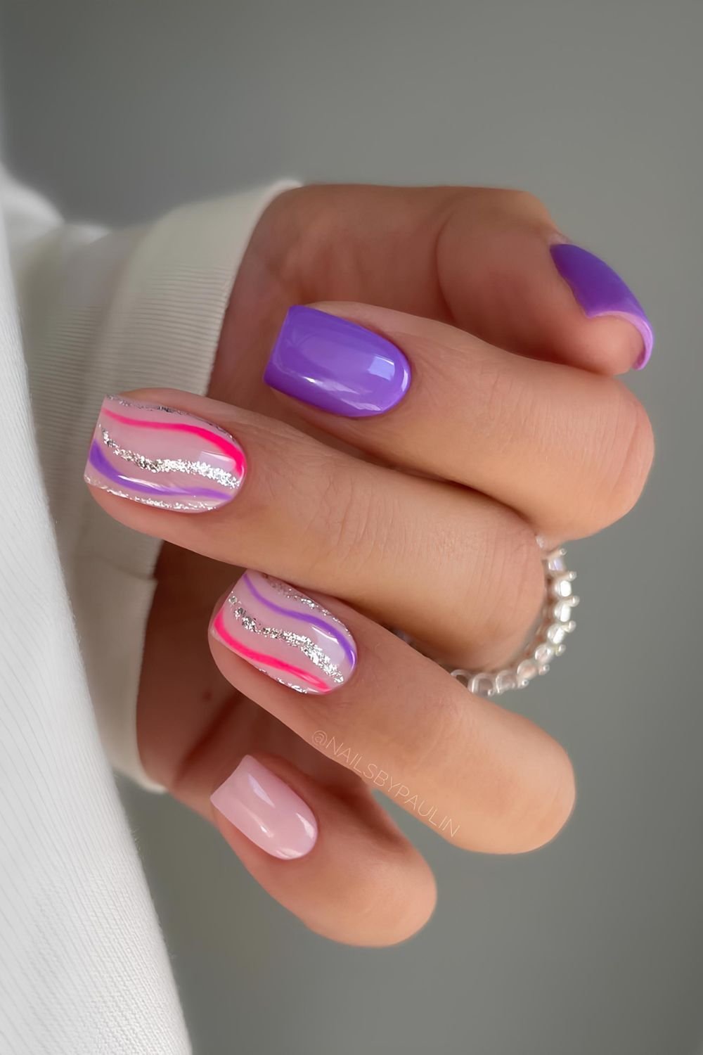 Purple nails with swirls in hot pink, purple and silver glitter