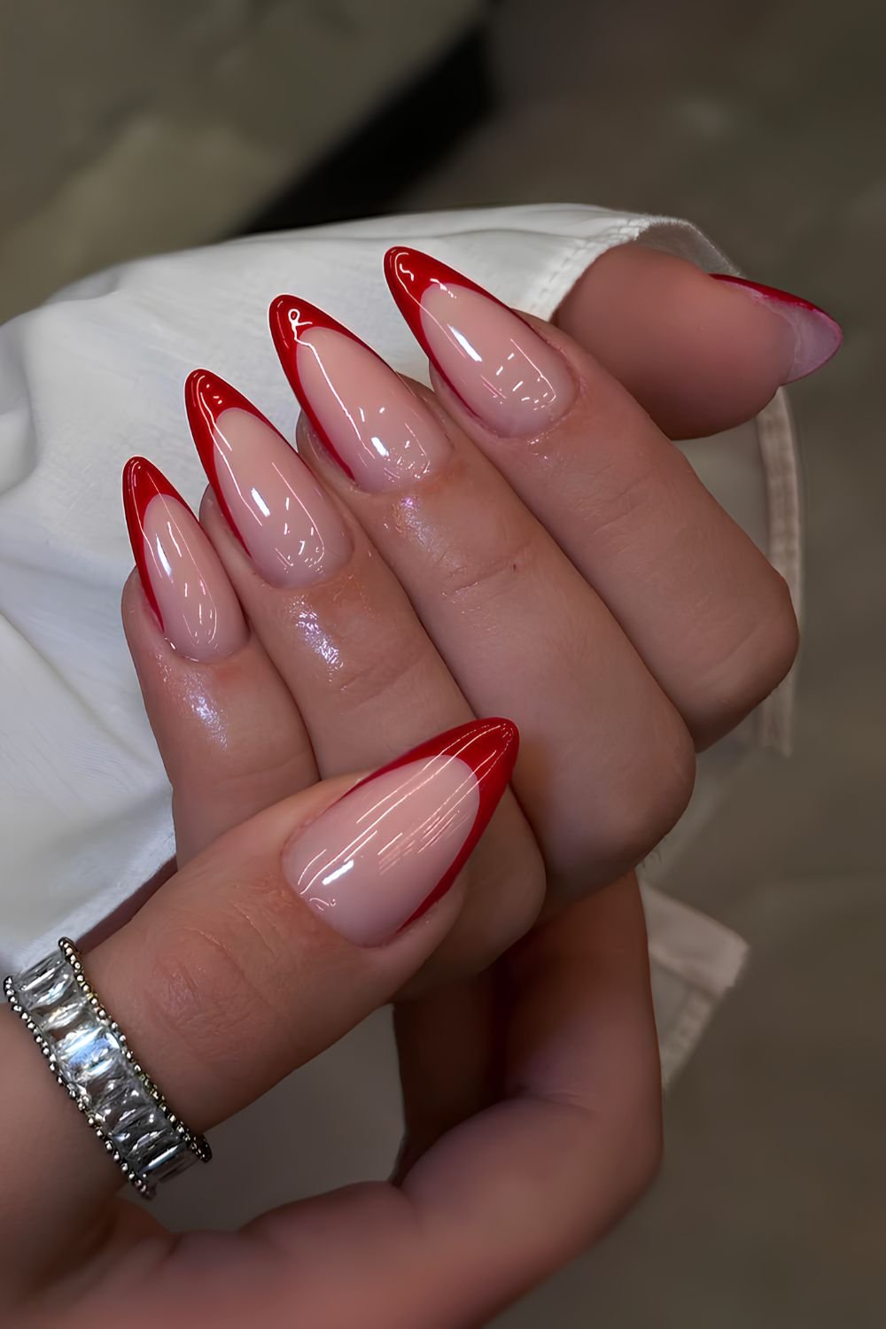 Red French tip manicure on a milky base