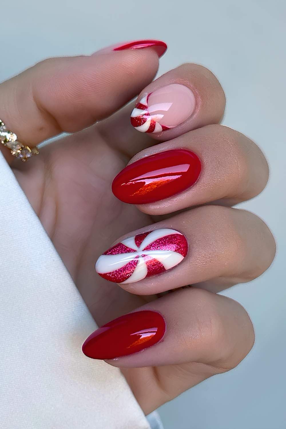 Red almond nails with peppermint swirl art