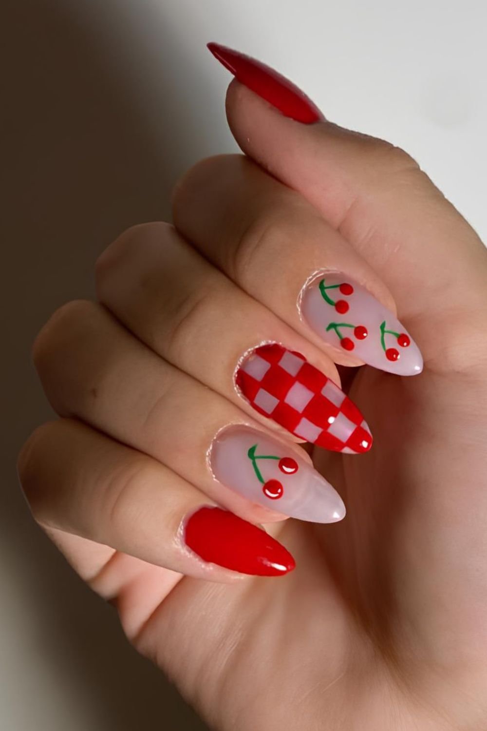 Red and milky nails with checkerboard accent and cherries