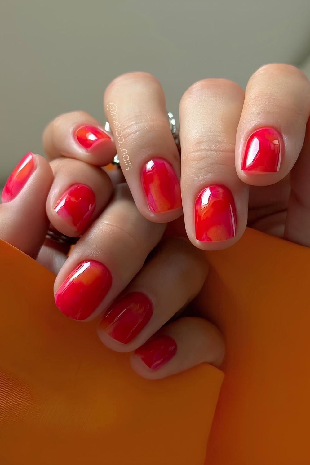 Red and orange glossy nails with marble effect