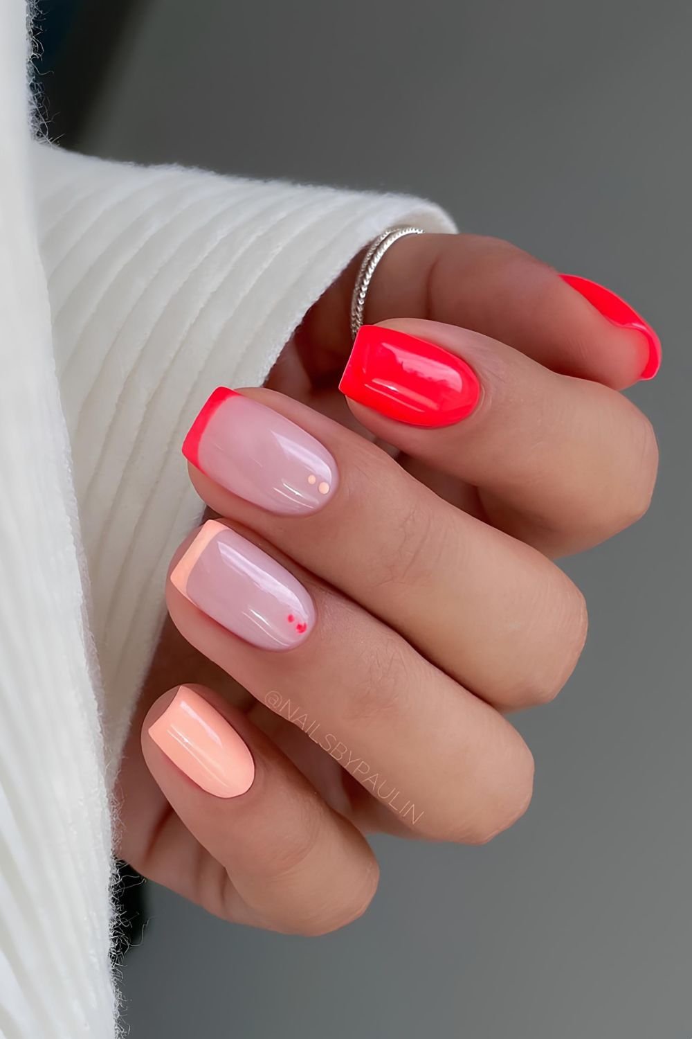 Red and orange neon nails with dot accents