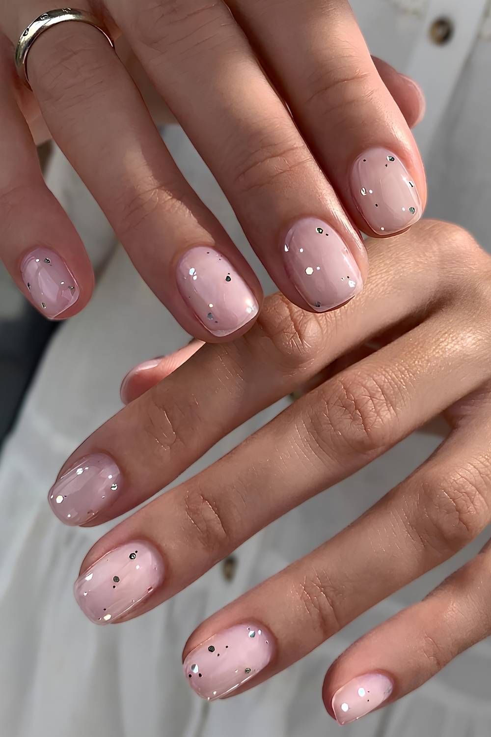 Sheer pink nails with accent glitter specks