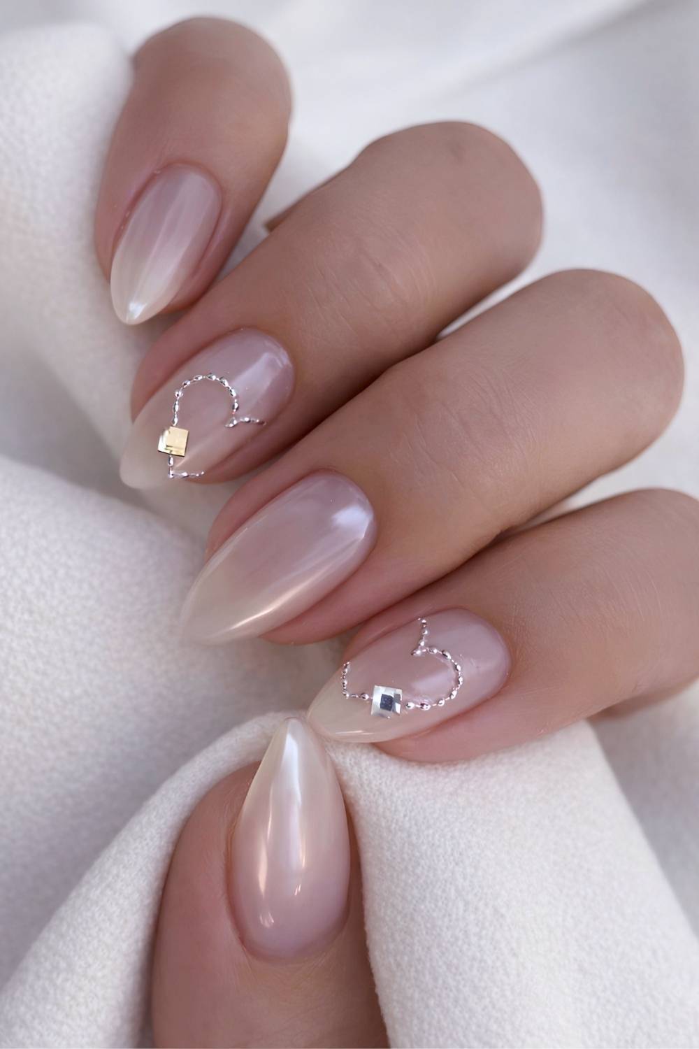 Sheer white chrome nails with hearts and gems