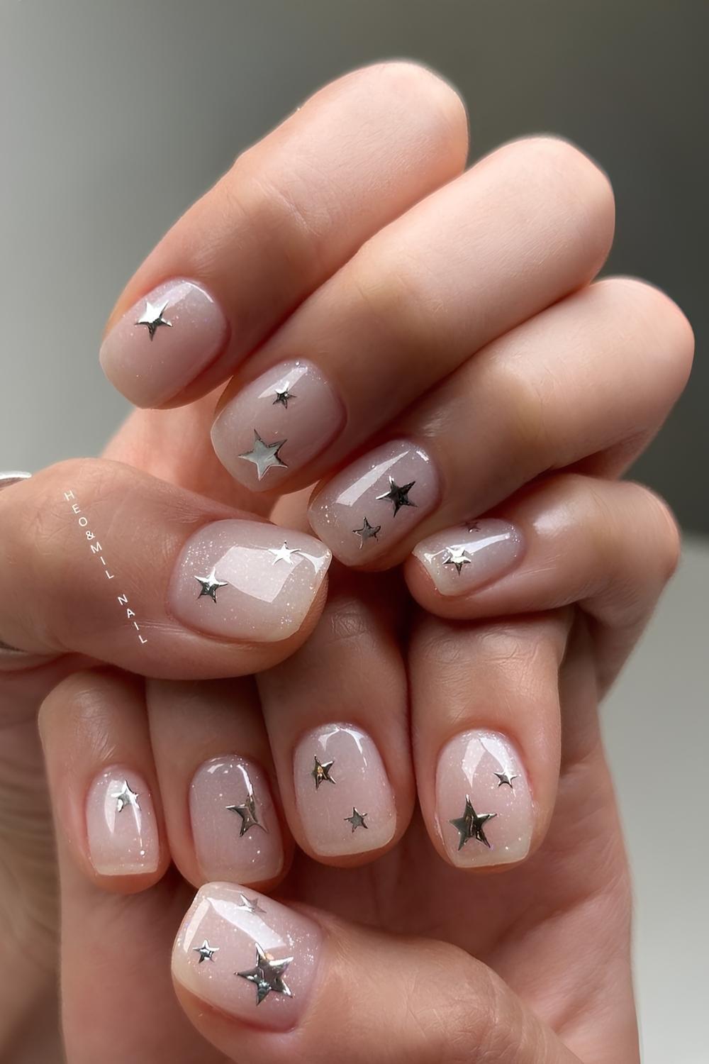 Sheer white nails with silver chrome stars