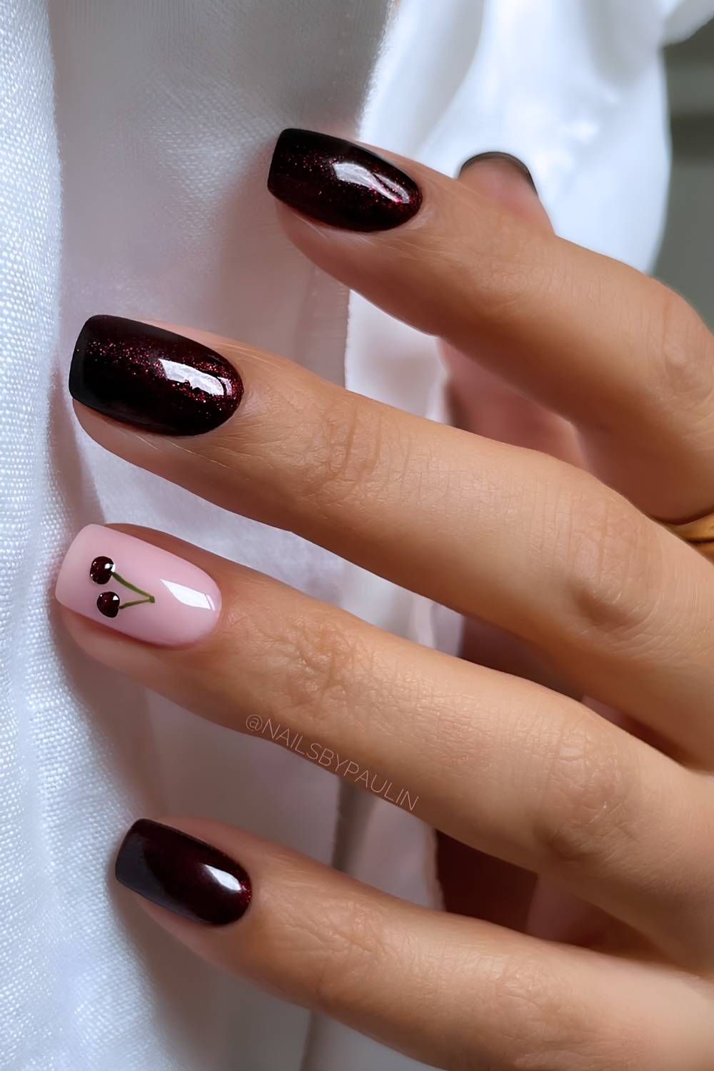 Shimmery deep red mani with cherry art
