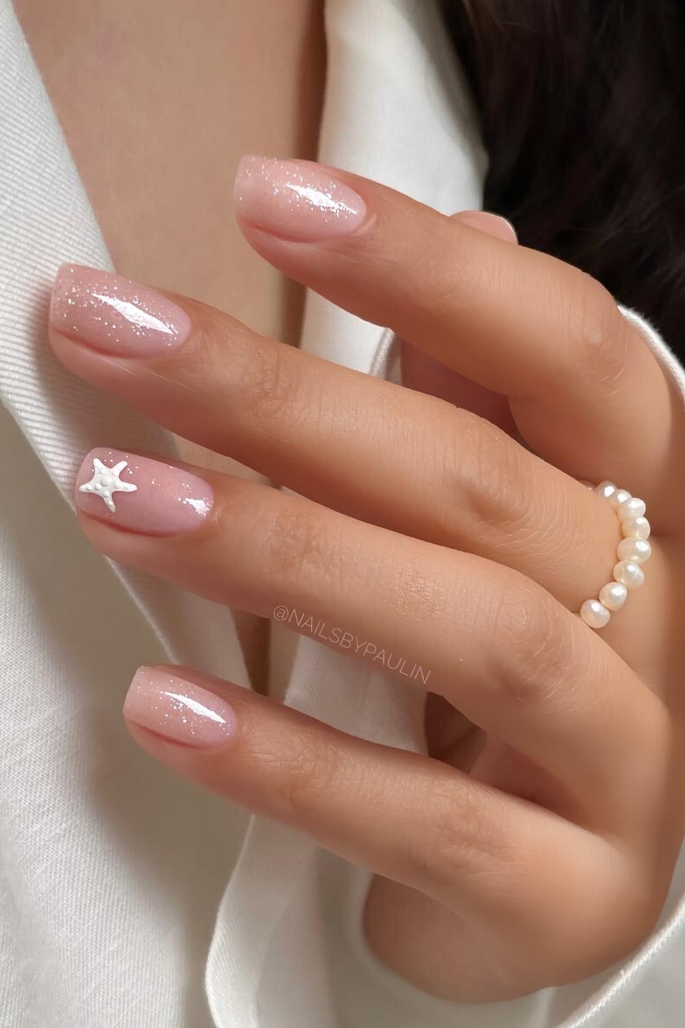 Shimmery neutral nails with subtle starfish art