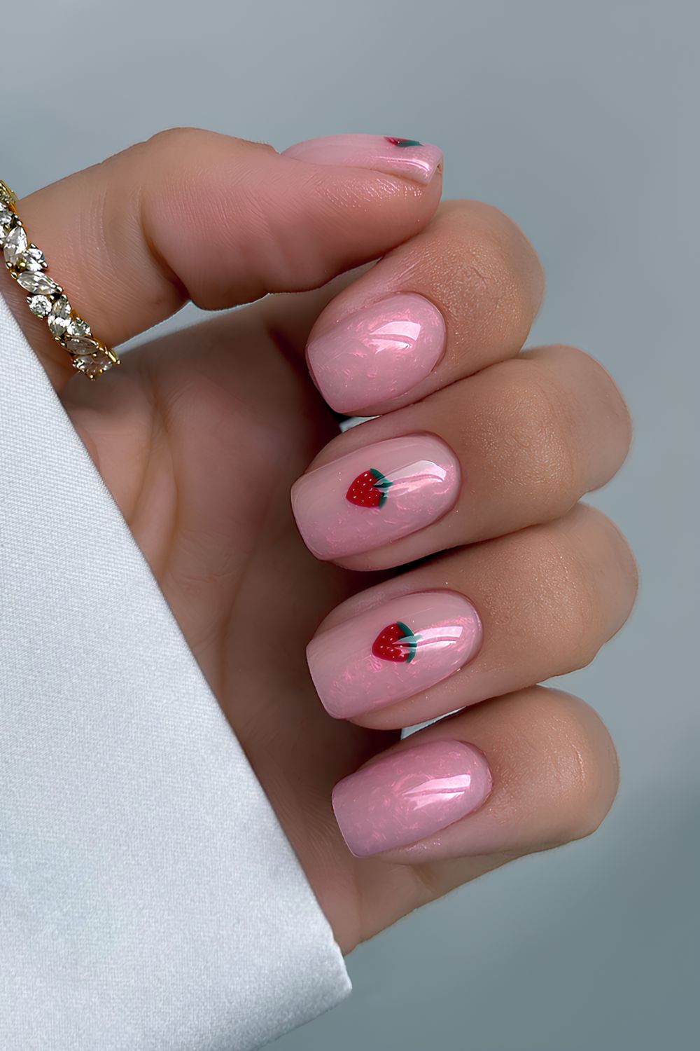 Shimmery pink nails with strawberries