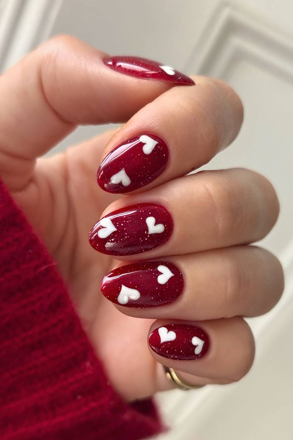 Shimmery red nails with white hearts