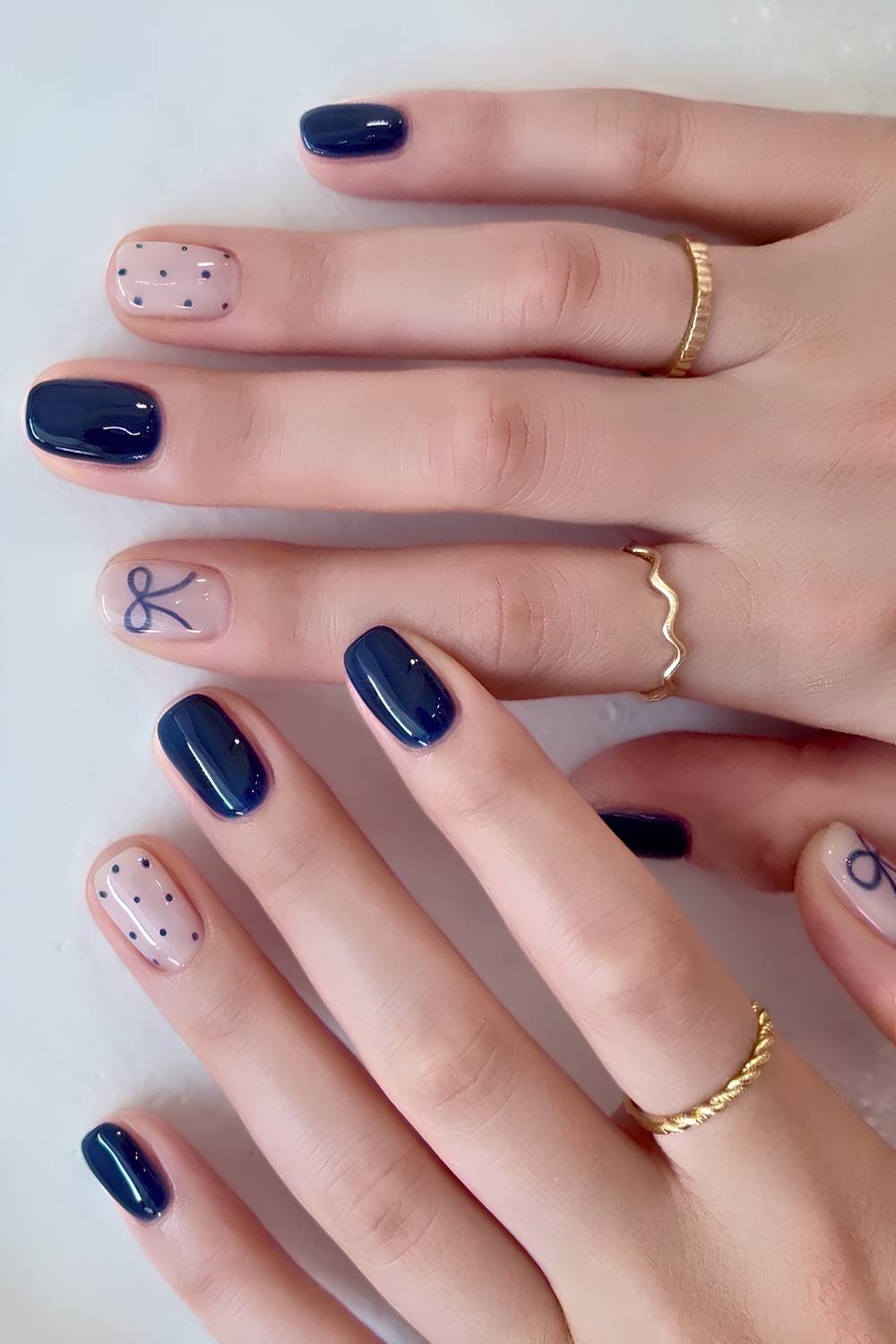 Short navy blue nails with bows and polka dots
