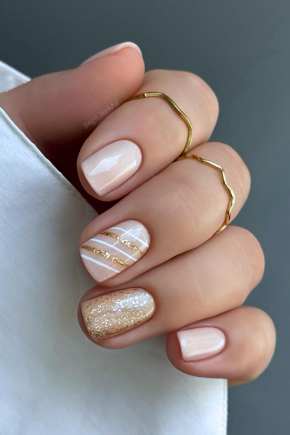 Short neutral mani with gold Christmas-themed accents