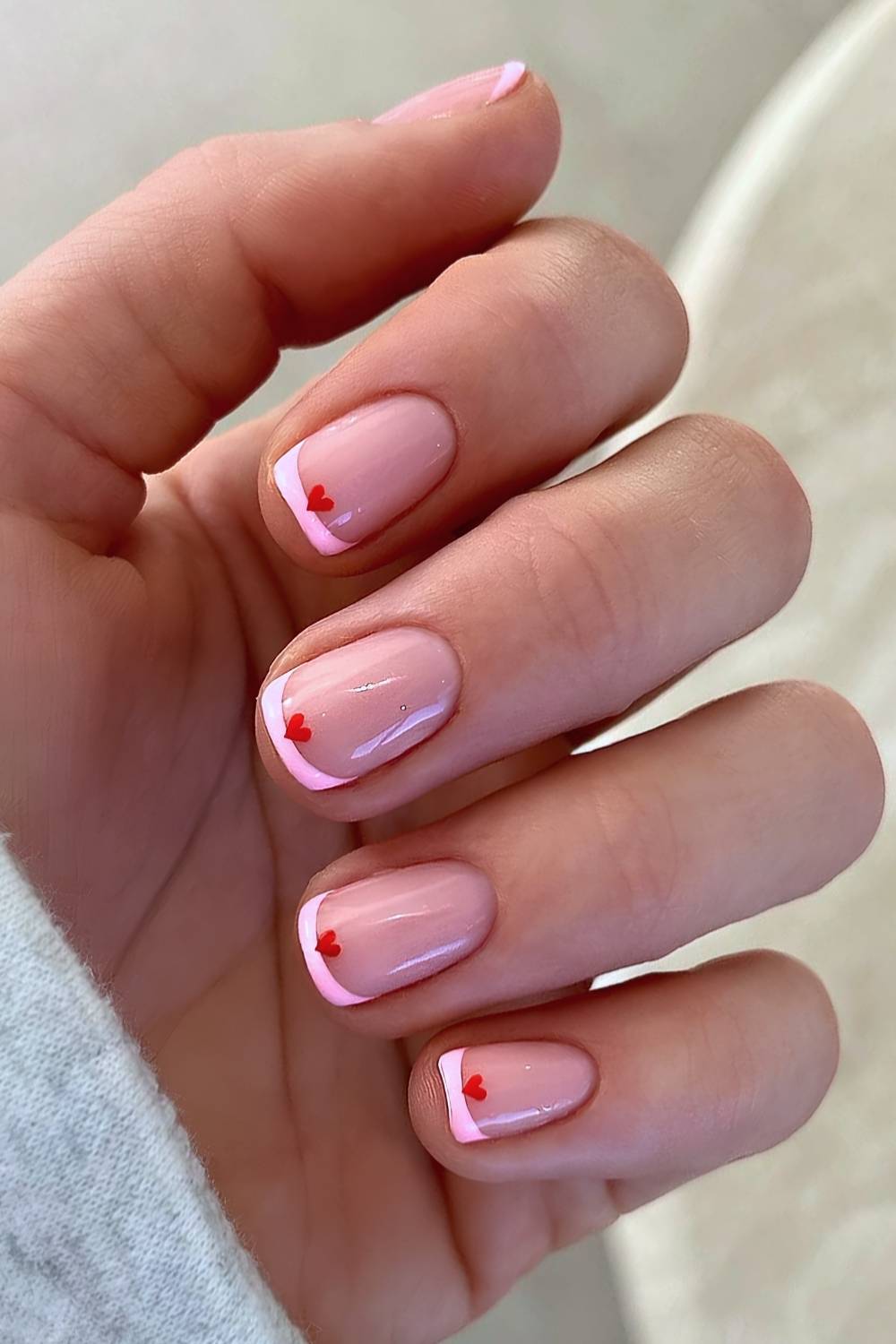 Short pink French mani with red hearts