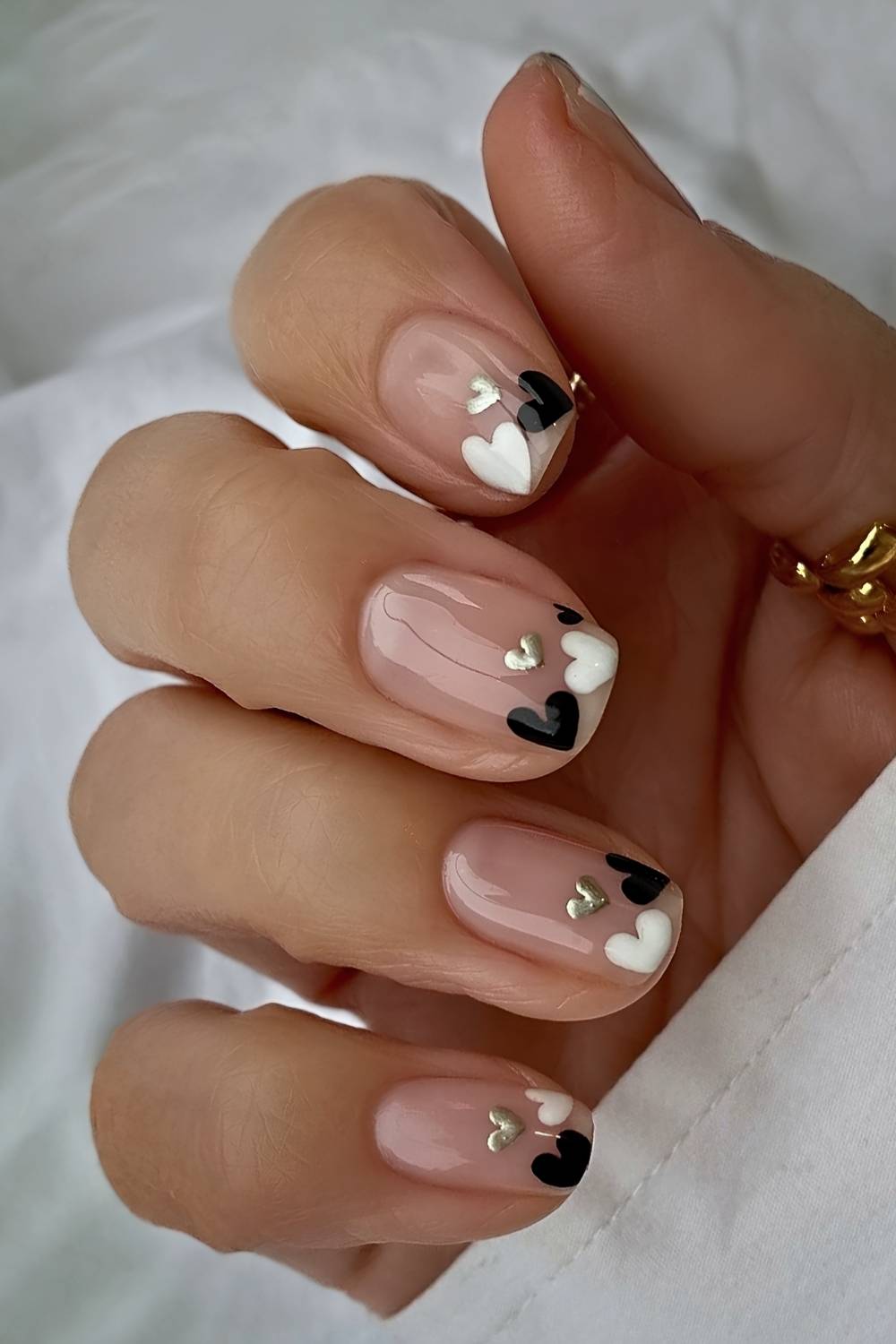 Short sheer nails with black and white hearts