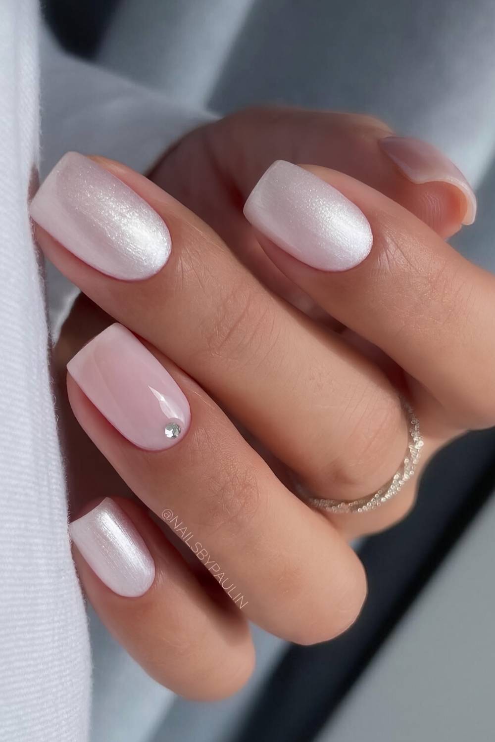 Short white satin nails with accent gem