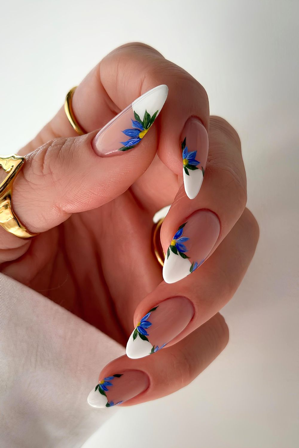 White French nails with oversized blue flowers