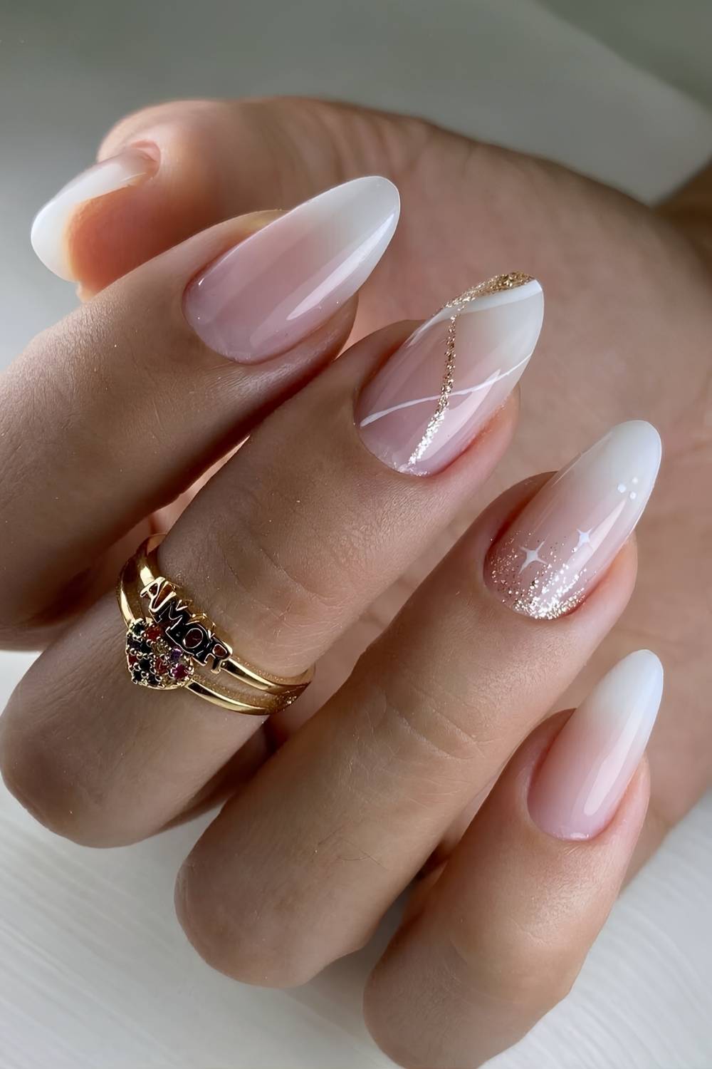 White ombre nails with gold glitter and stars