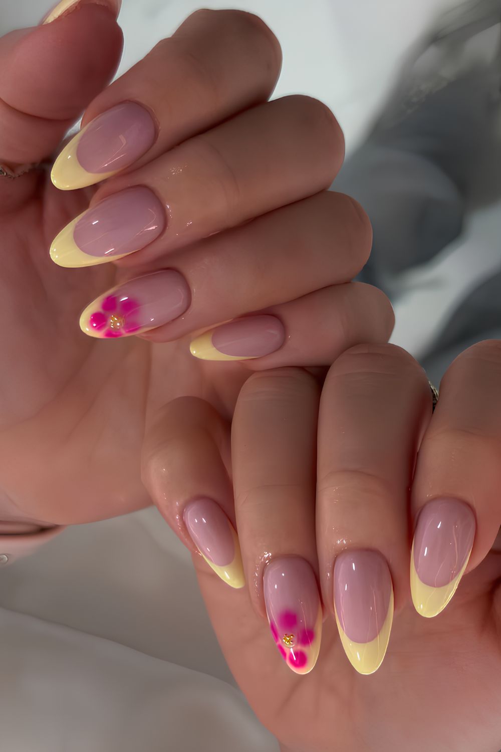 Yellow French mani with pink blooming flowers