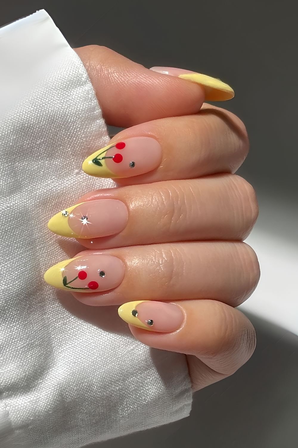 Yellow French nails with gems and cherries