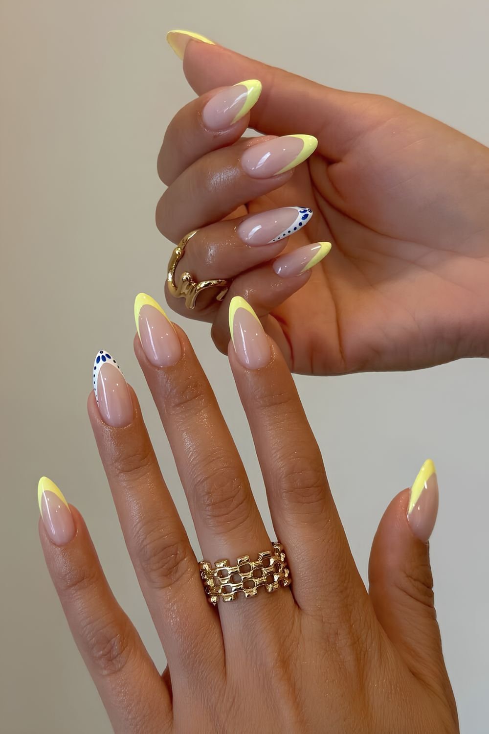 Yellow French tip nails with blue and white tip accents