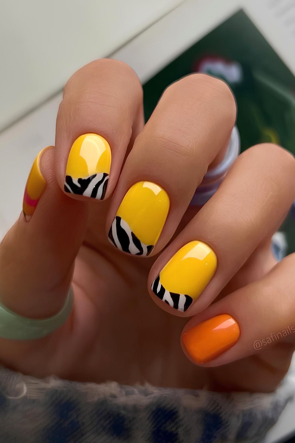 Yellow and orange nails with zebra print accents