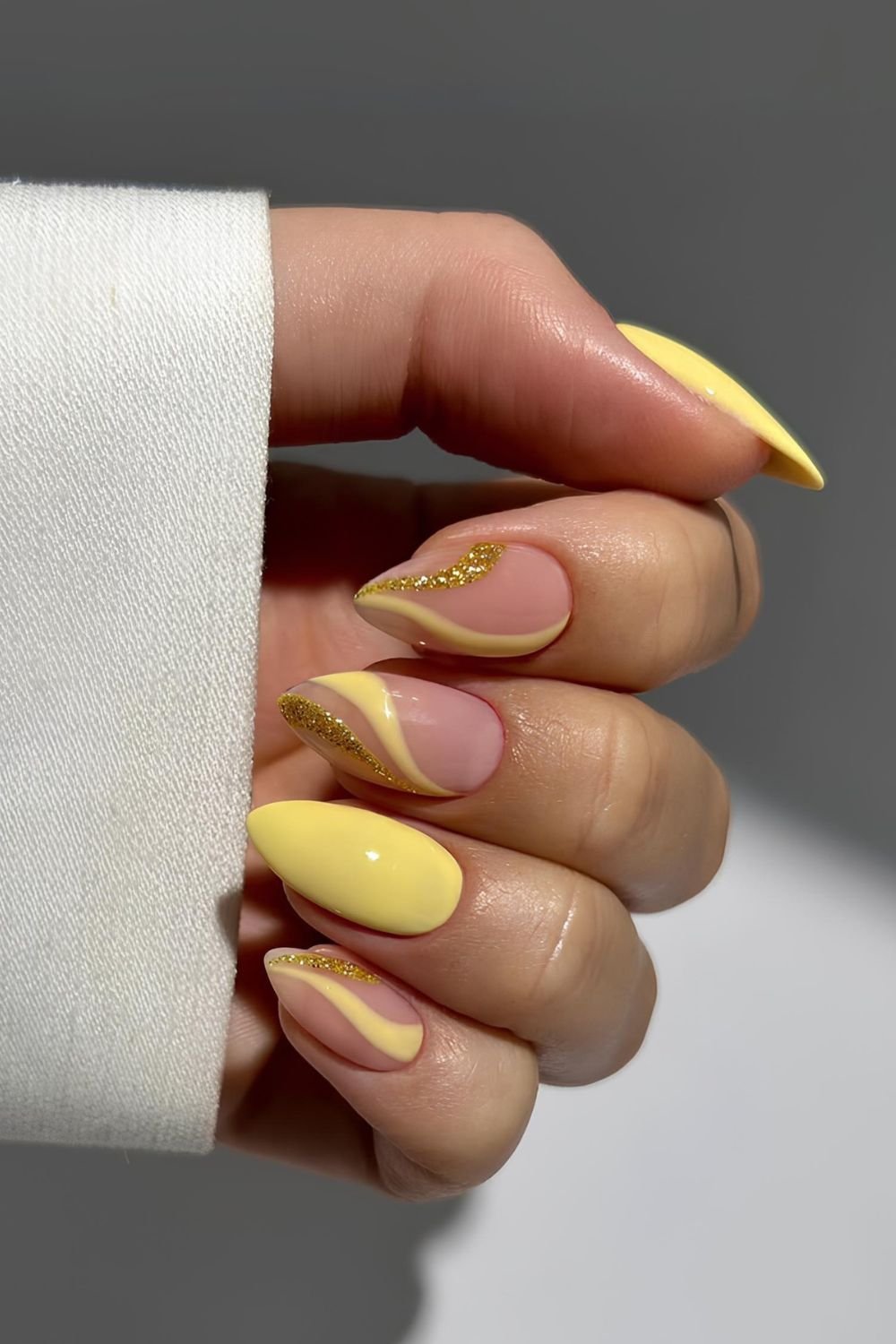 Yellow nails with yellow and glittery gold swirls